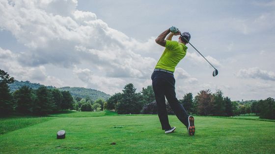 Golfer at the finish of a drive from the tee